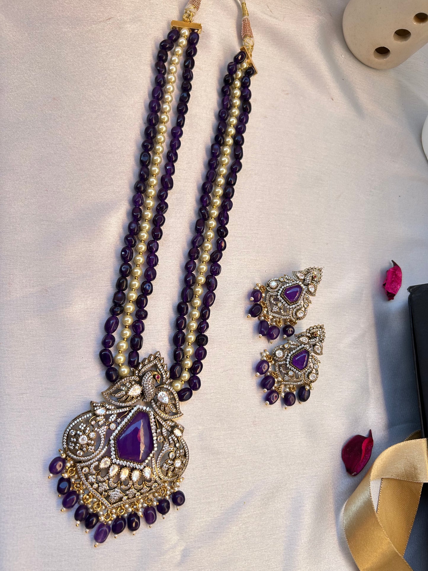 Elegant Kiara Kundan Necklace Set with purple and gold beads, featuring intricate stonework and matching earrings.