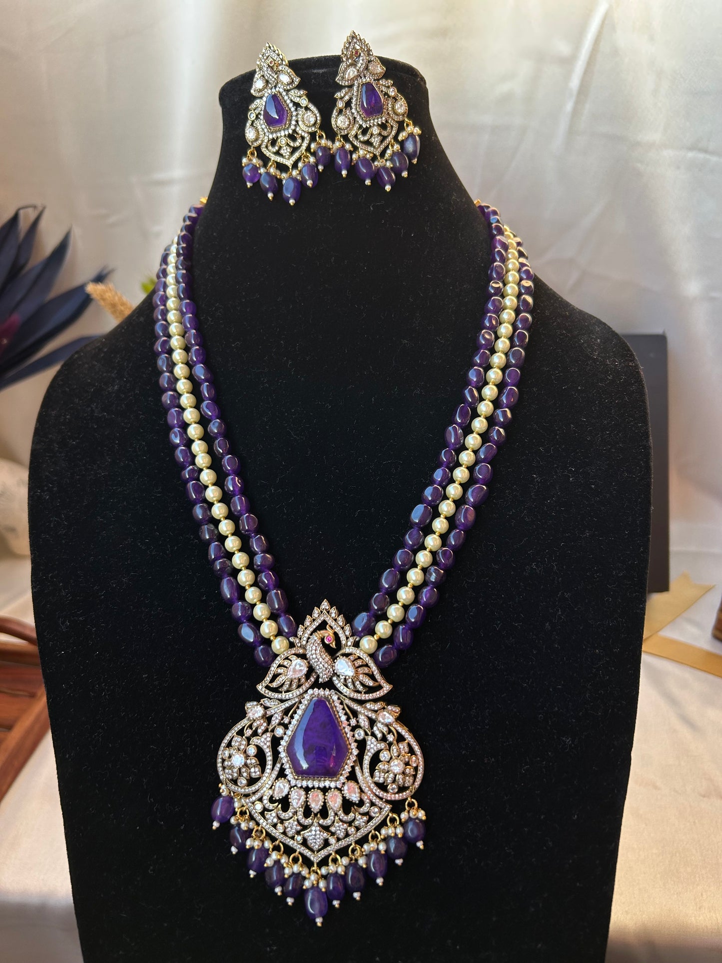 Elegant Kiara Kundan Necklace Set with purple and gold beads, featuring intricate stonework and matching earrings.
