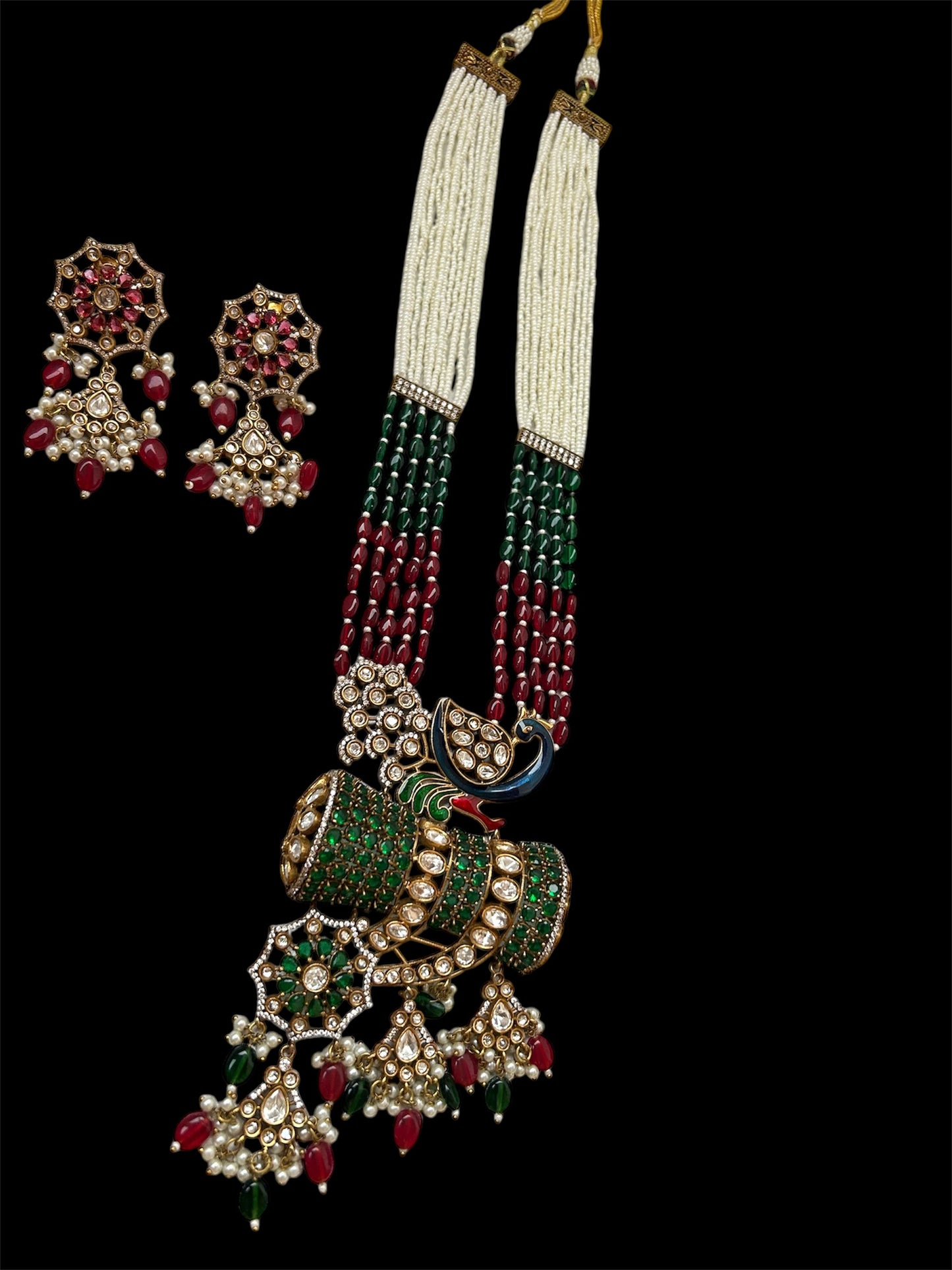 Kundan Rani Haar set with ivory pearl strands, red and green beads, and intricate gold detailing, paired with statement earrings.