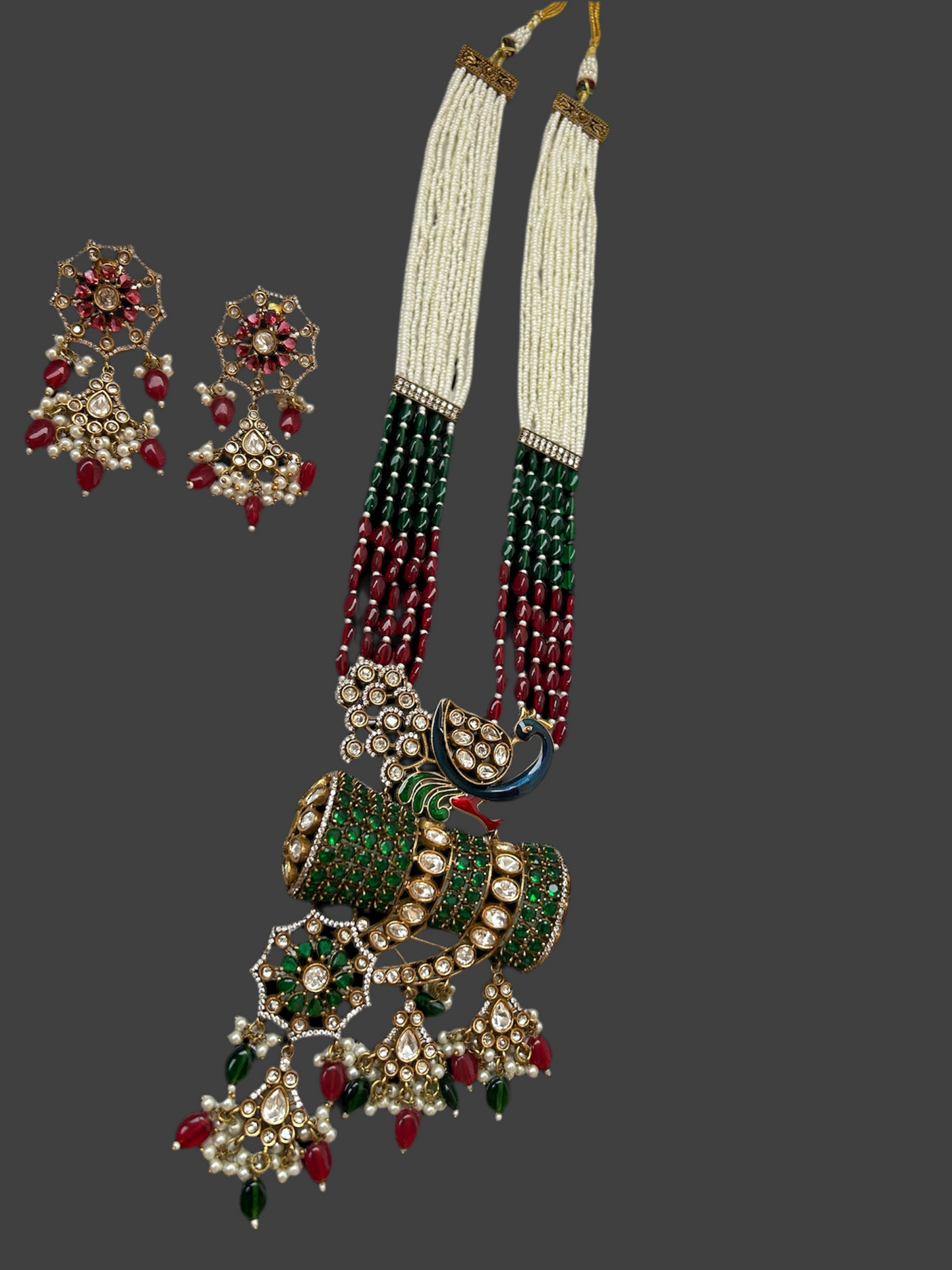 Kundan Rani Haar set with ivory pearl strands, red and green beads, and intricate gold detailing, paired with statement earrings.