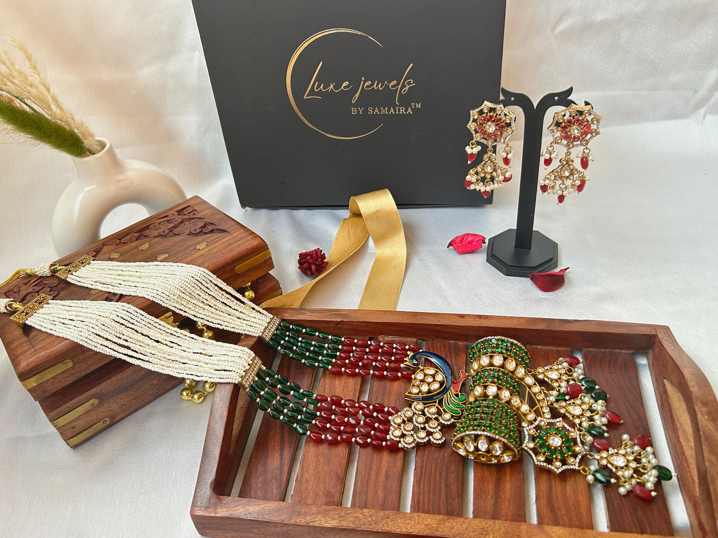 Kundan Rani Haar set with ivory pearl strands, red and green beads, and intricate gold detailing, paired with statement earrings.