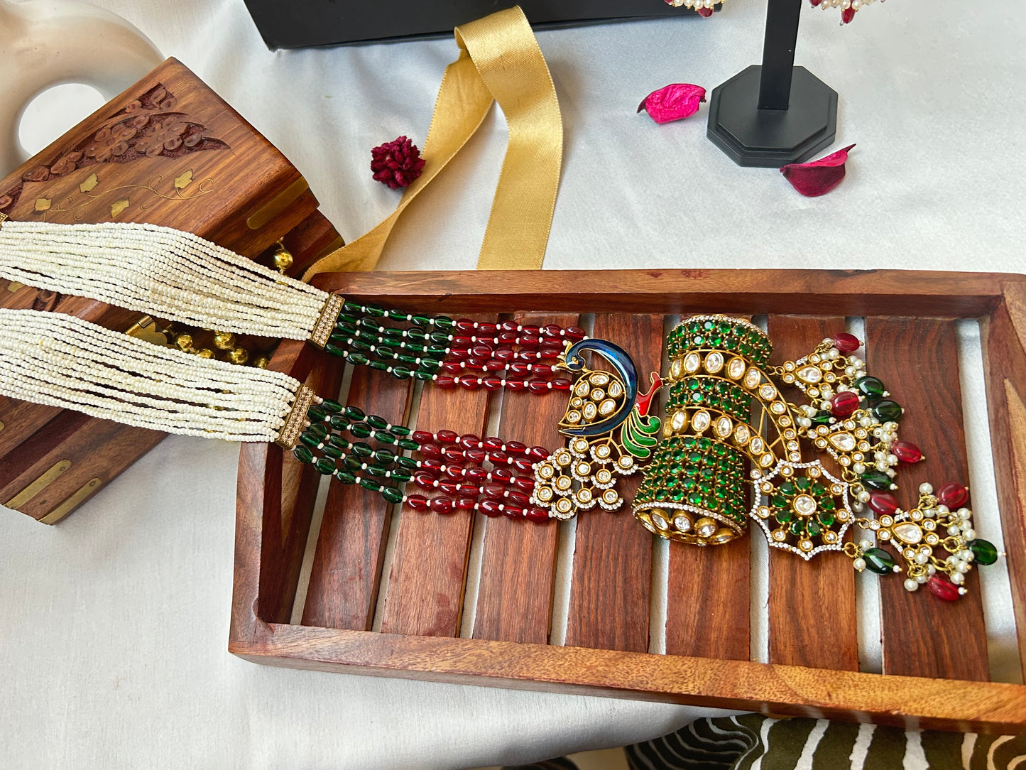 mughal Kundan Rani Haar set with ivory pearl strands, red and green beads, and intricate gold detailing, paired with statement earrings.