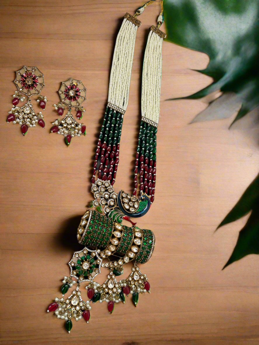 Kundan Rani Haar set with ivory pearl strands, red and green beads, and intricate gold detailing, paired with statement earrings.