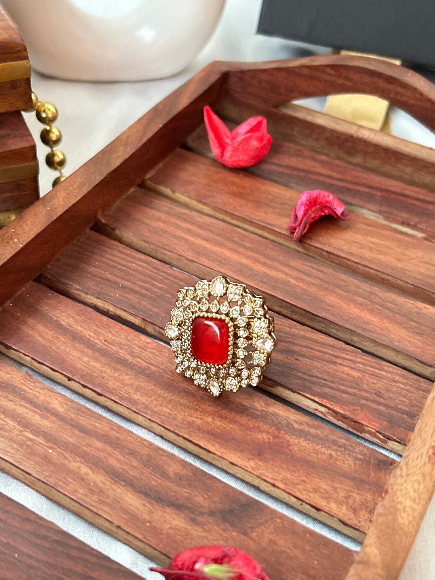 Square-cut ruby red ring with intricate gold and American diamond detailing
