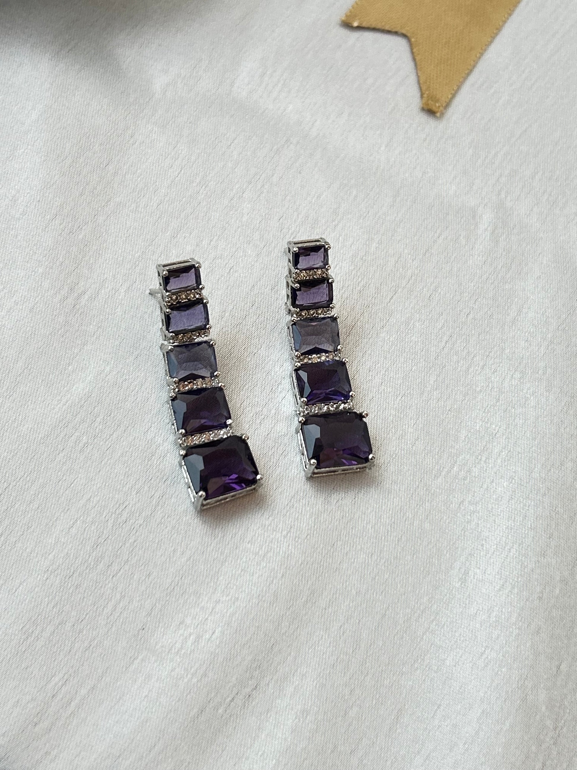 Long violet-purple earrings with American diamonds and white gold plating.