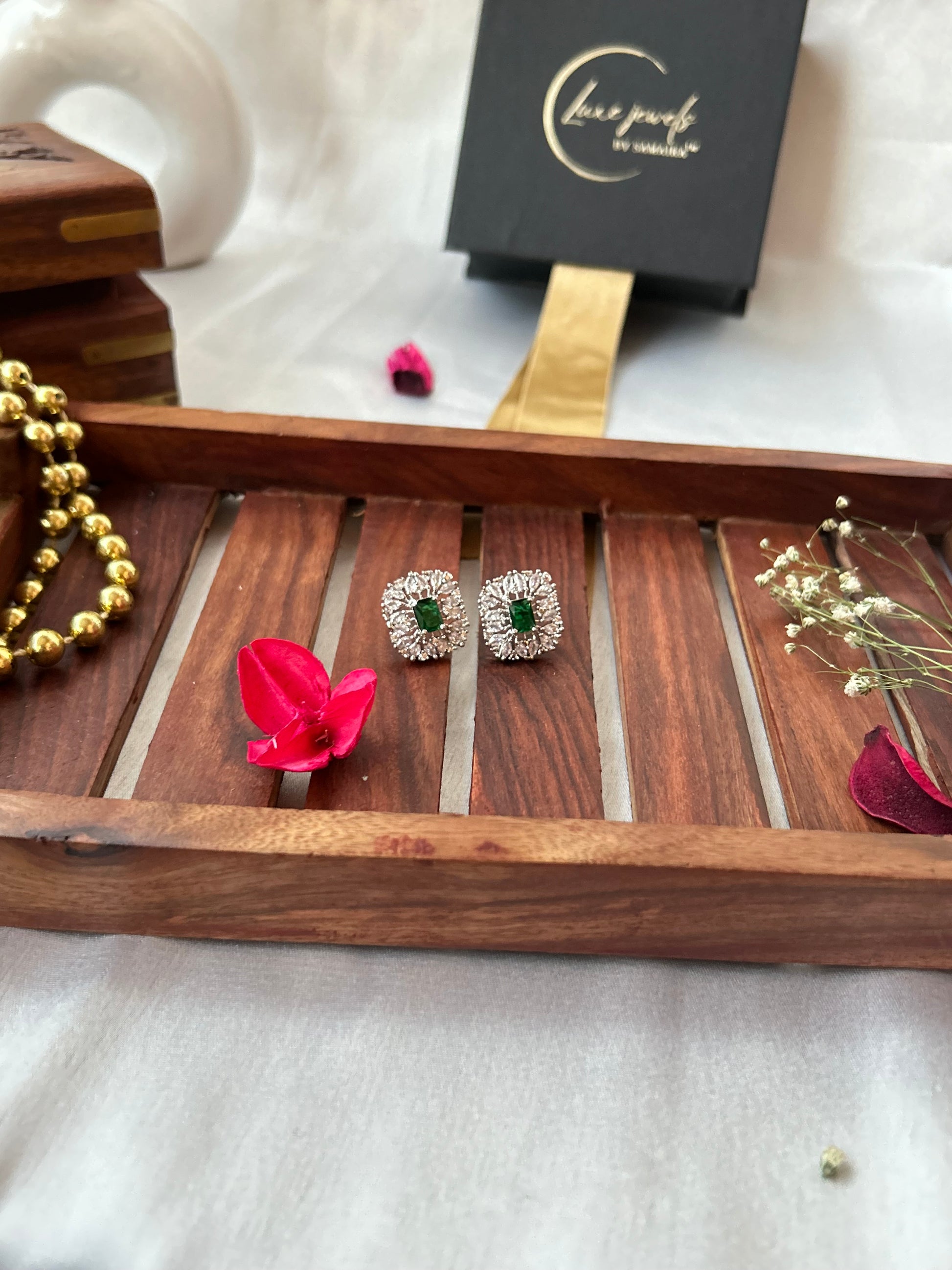 Emerald green stud earrings with American diamonds in a silver-plated setting