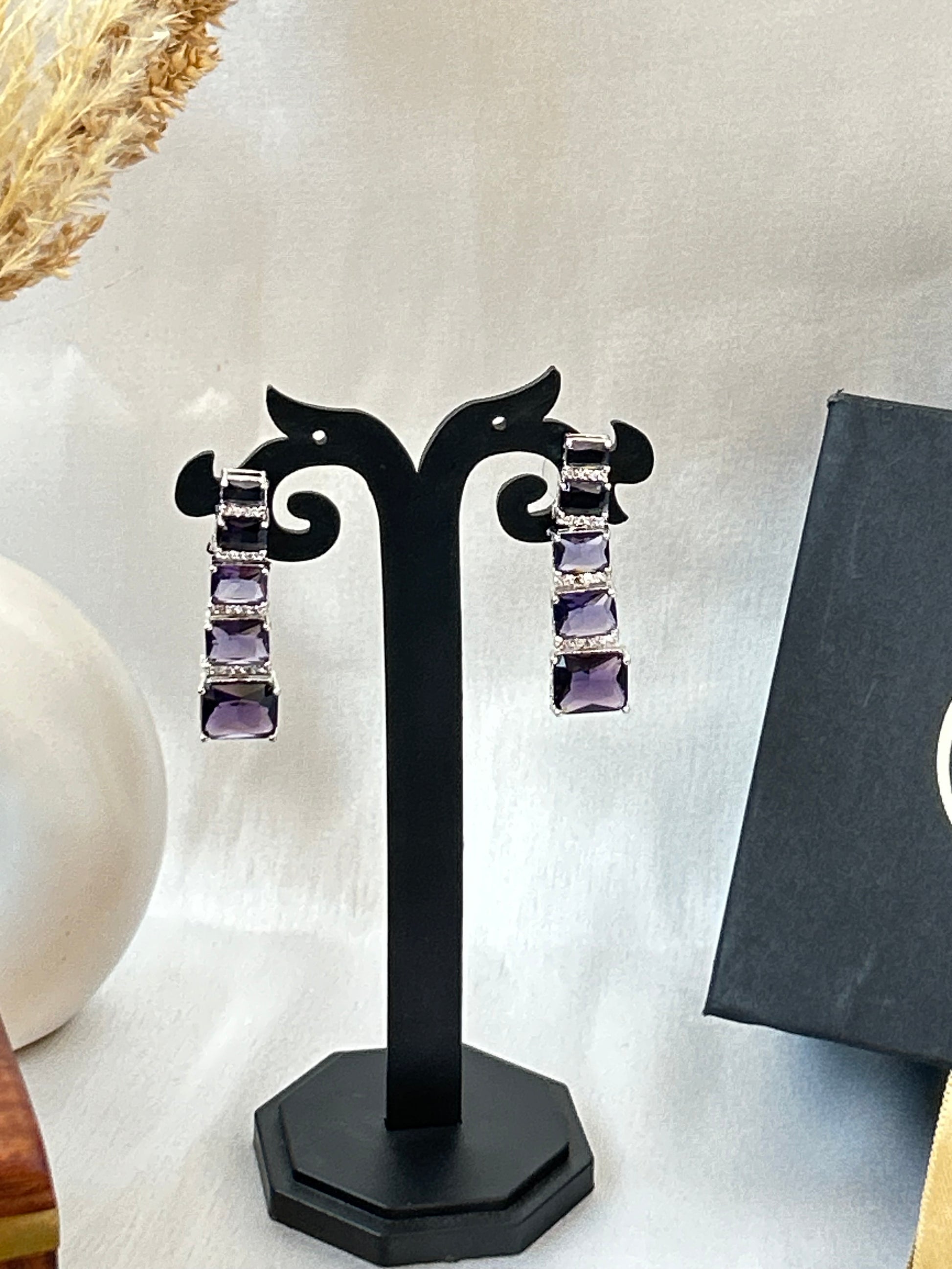Long violet-purple earrings with American diamonds and white gold plating.