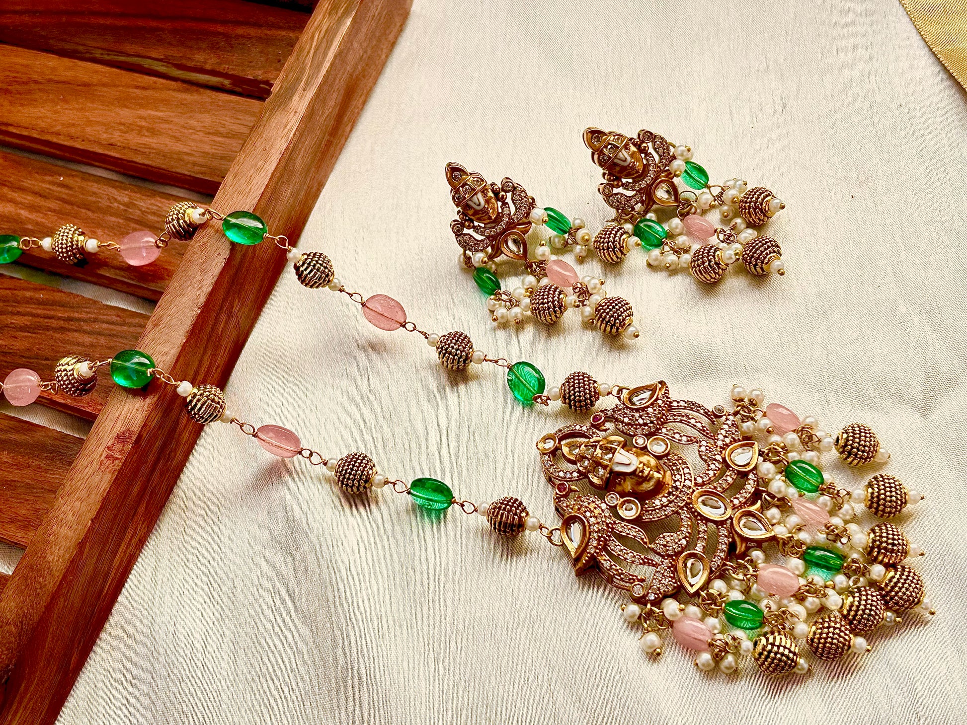 Keshavi Temple Necklace Set – Gold-plated Kundan jewelry with Goddess Lakshmi pendant, pearls, and green-pink beads"