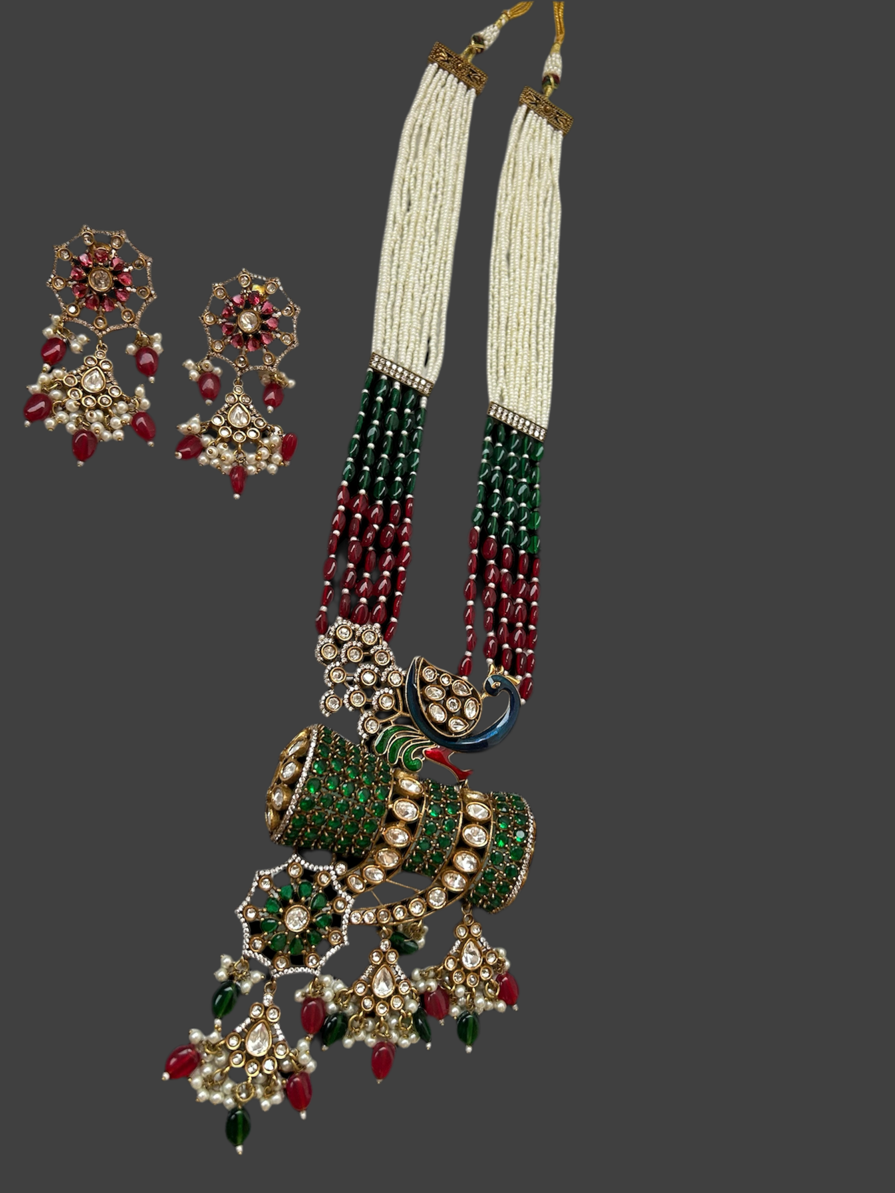  Kundan Rani Haar set with ivory pearl strands, red and green beads, and intricate gold detailing, paired with statement earrings.