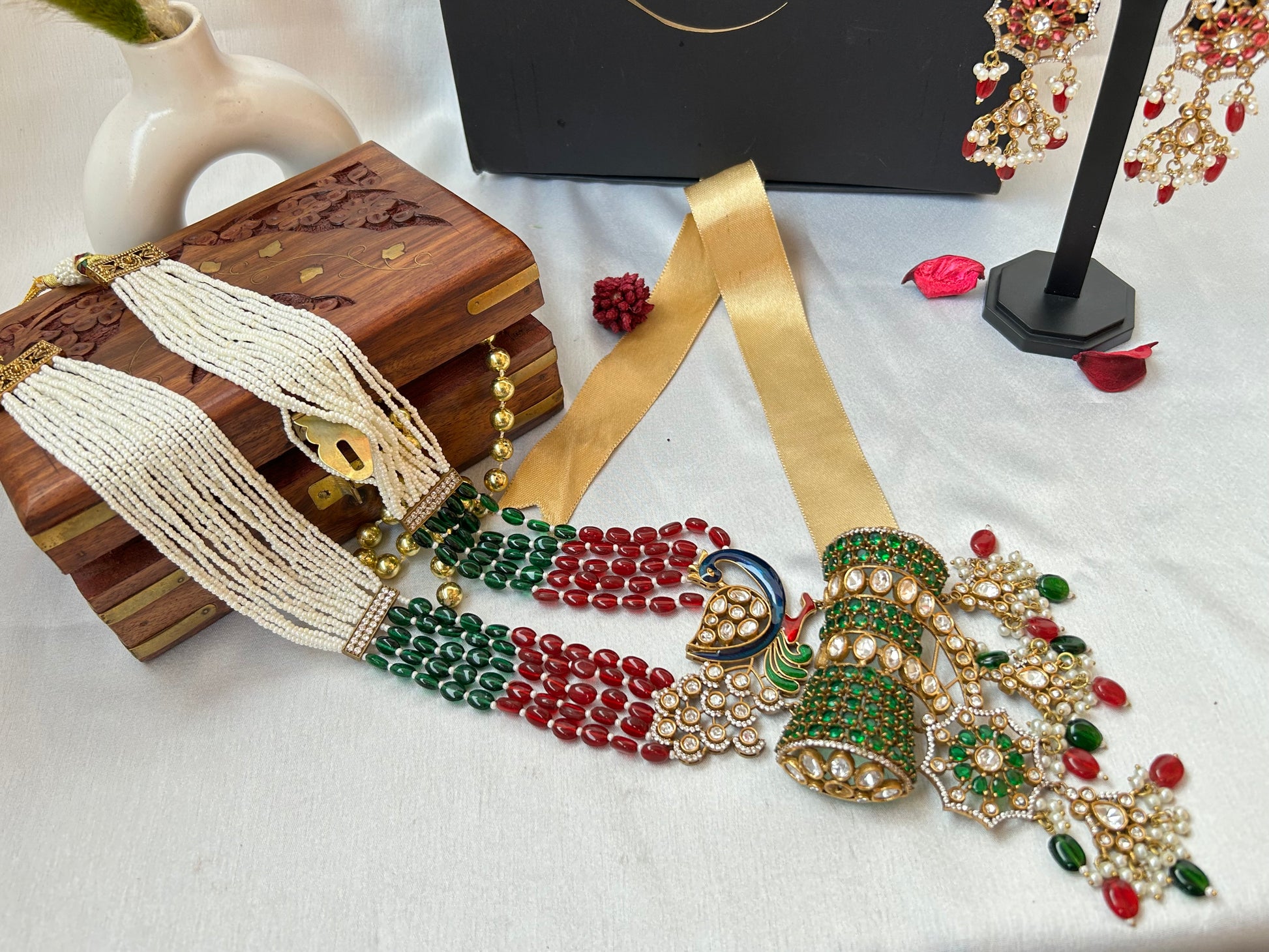  Kundan Rani Haar set with ivory pearl strands, red and green beads, and intricate gold detailing, paired with statement earrings.
