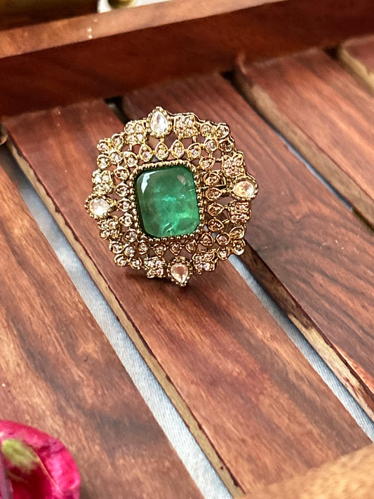 Square-cut emerald green ring with intricate gold and American diamond detailing  