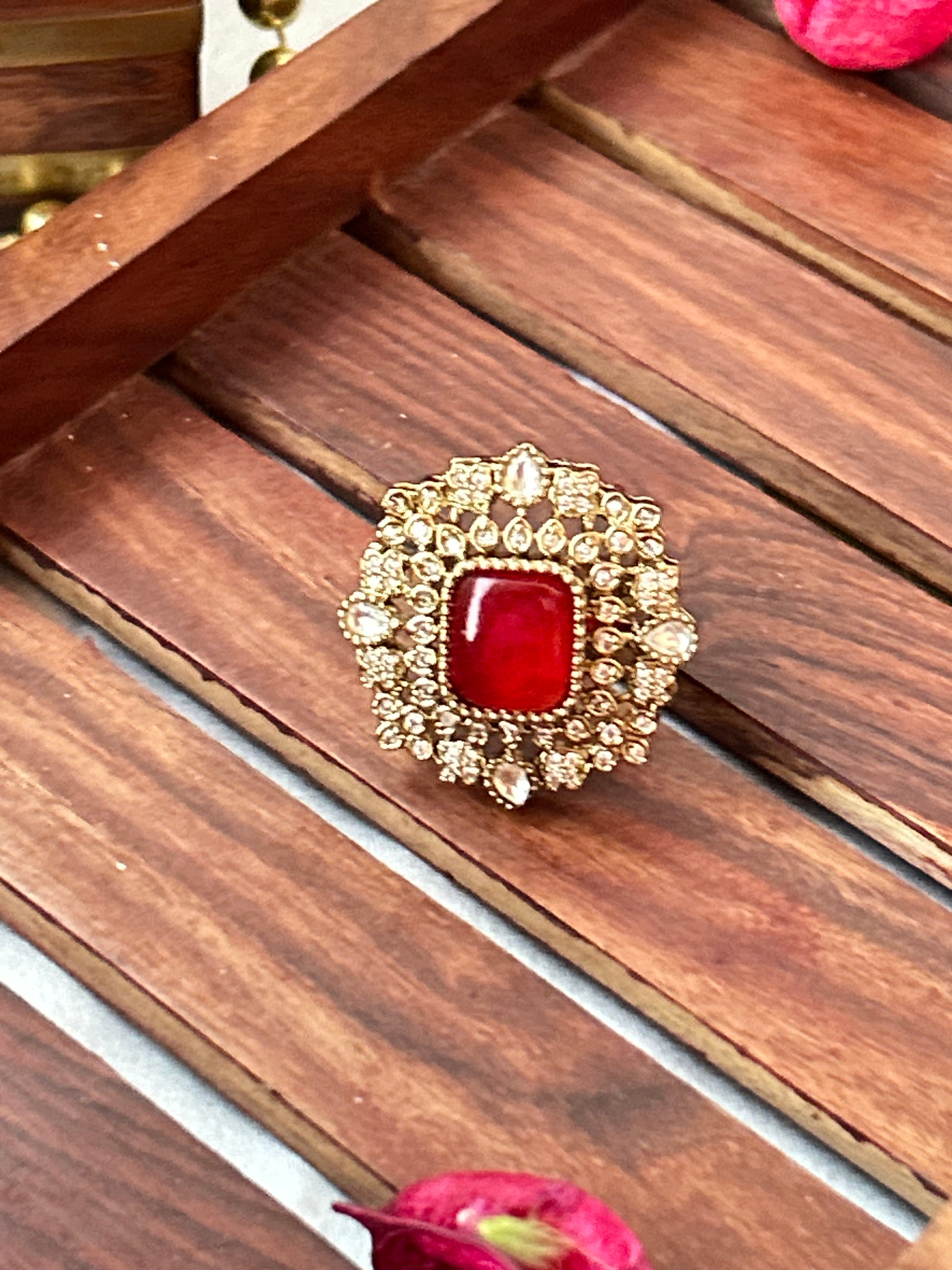 Square-cut ruby red ring with intricate gold and American diamond detailing  